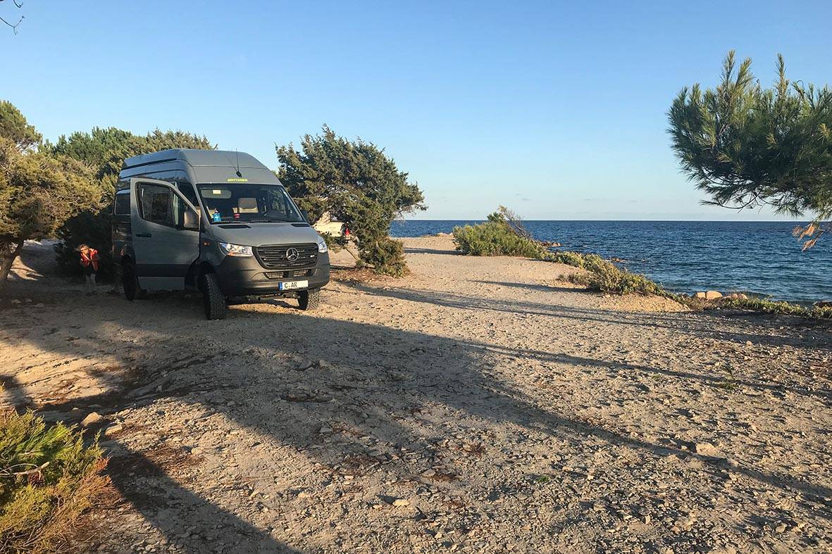 Der 4x4 Sprinter Camper steht am Strand am Mittelmeer auf Sardinien