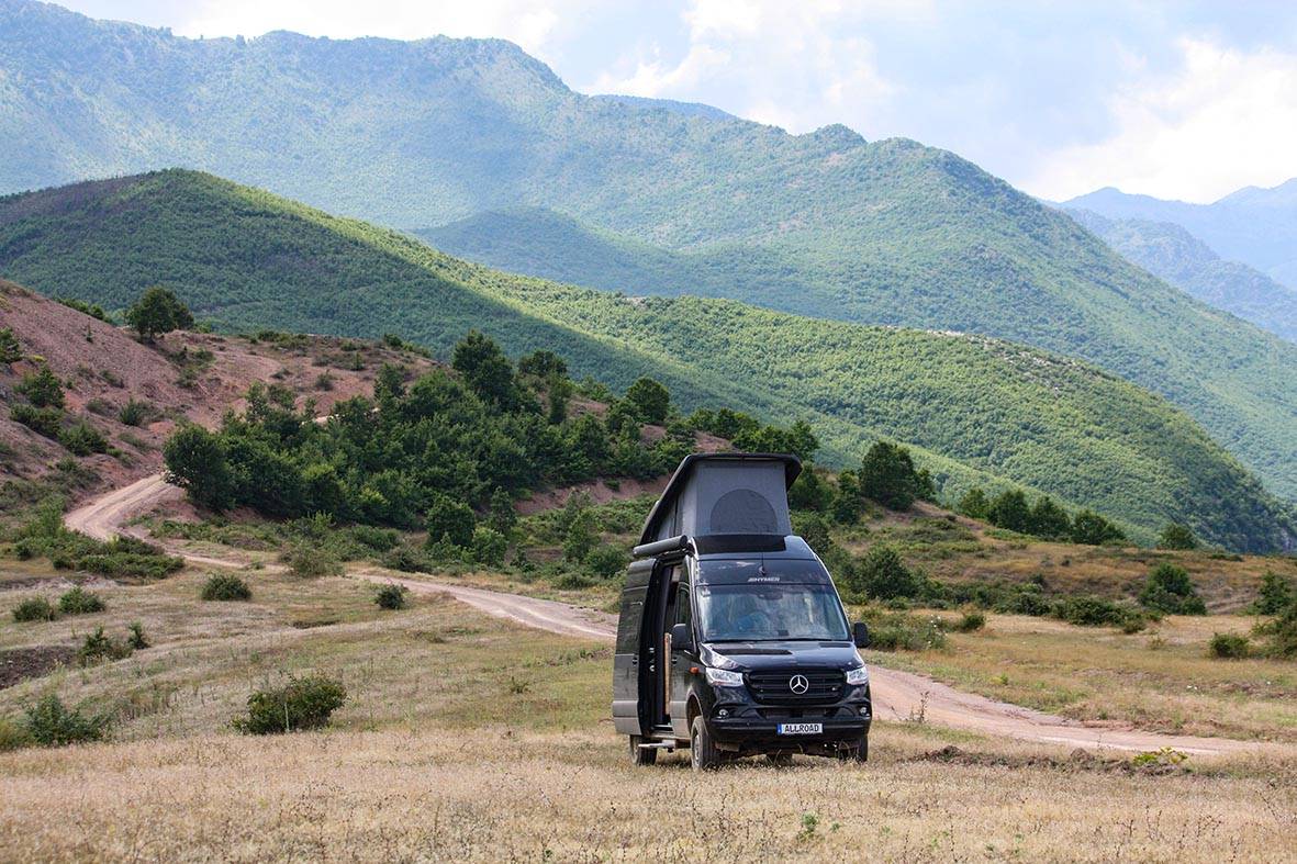 Hymer Grand Canyon S 4x4 steht in den Bergen von Albanien auf einer Wiese mit Klapp-Schlafdach